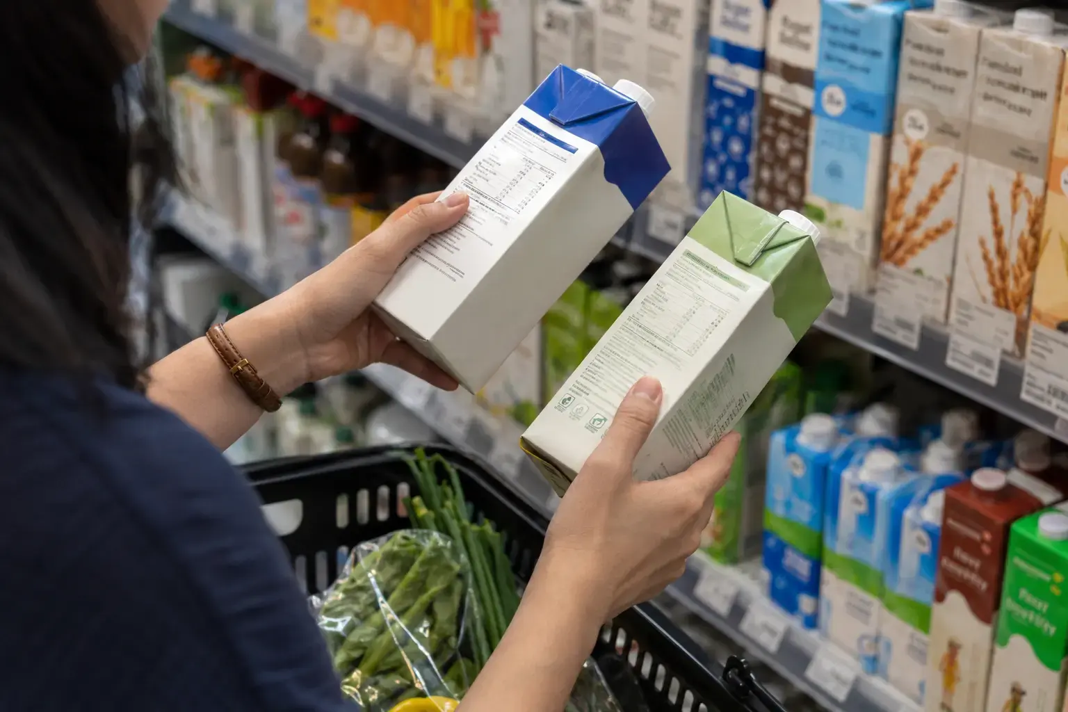 A Singapore shopper comparing beverage nutrition information in a supermarket